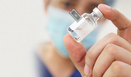 Hand holding tagged vial about us page.png